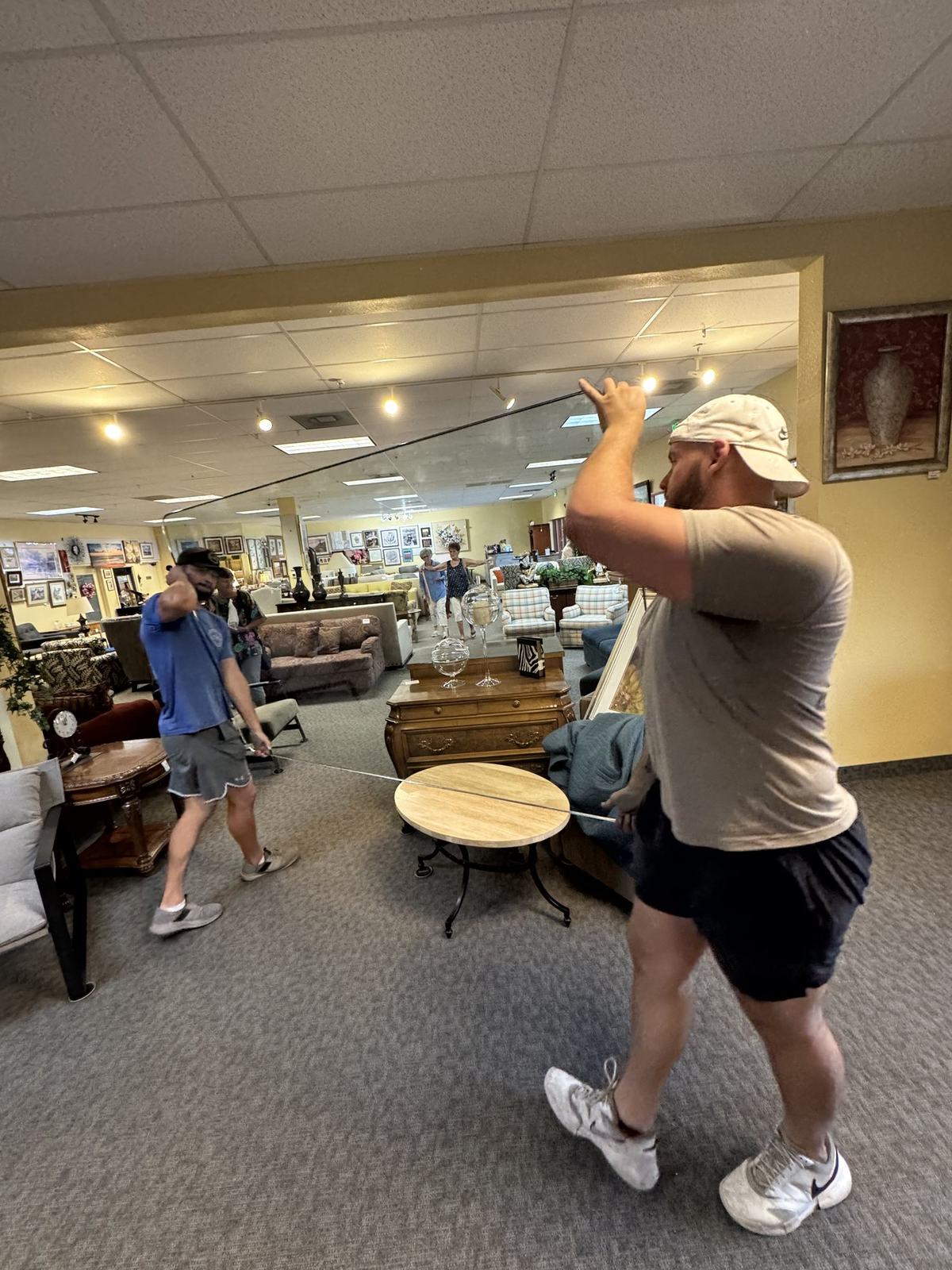 Just-In Time movers carrying furniture inside a retail showroom during a commercial delivery