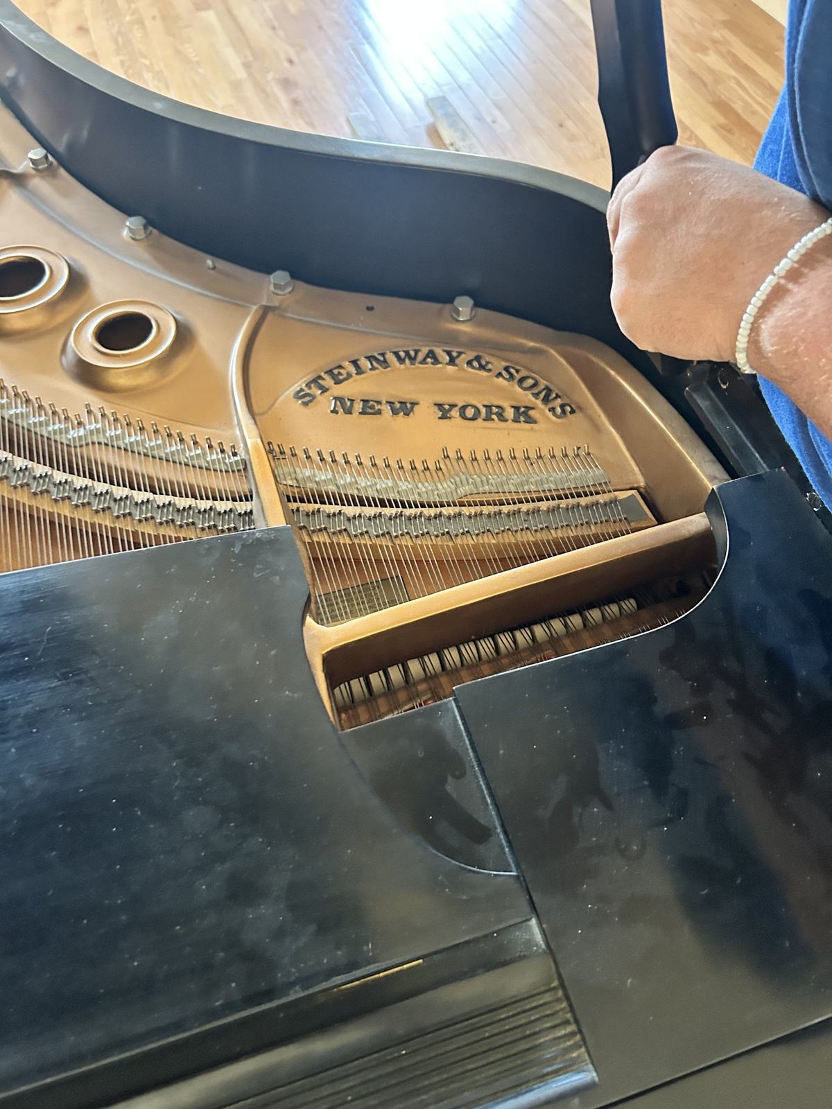 The soundboard of a Steinway and Sons grand piano being carefully handled by a Just-In Time mover