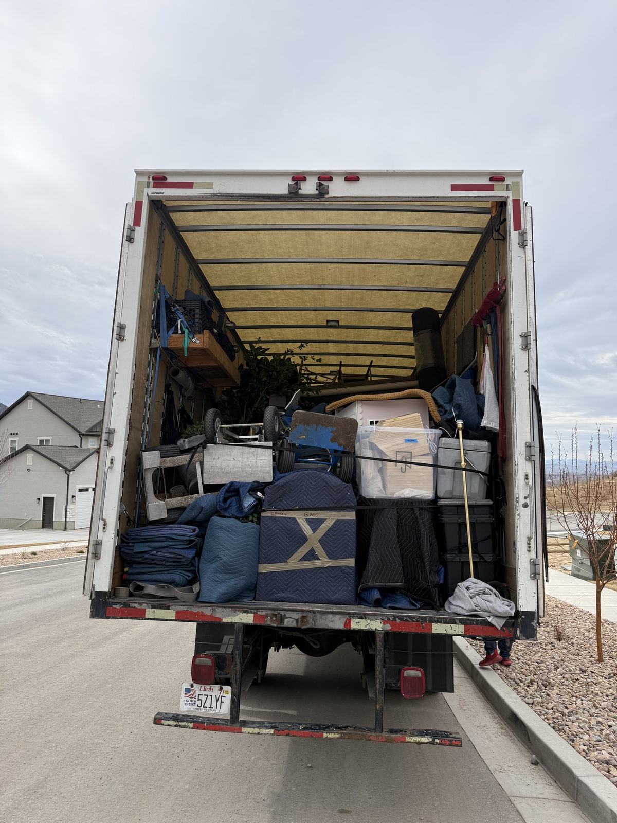 The rear of a Just-In Time moving truck parked outside a home, packed and ready for a Northern Utah move