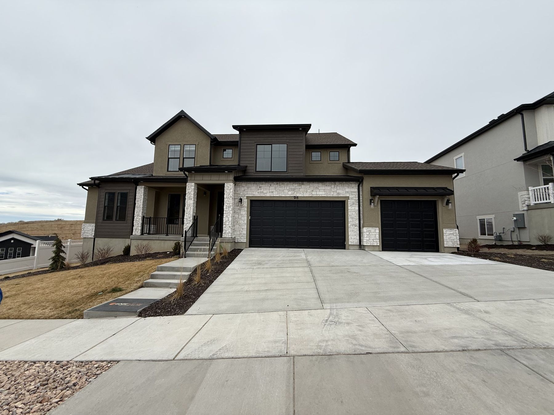 A modern two-storey Northern Utah home with a wide concrete driveway and double garage on moving day
