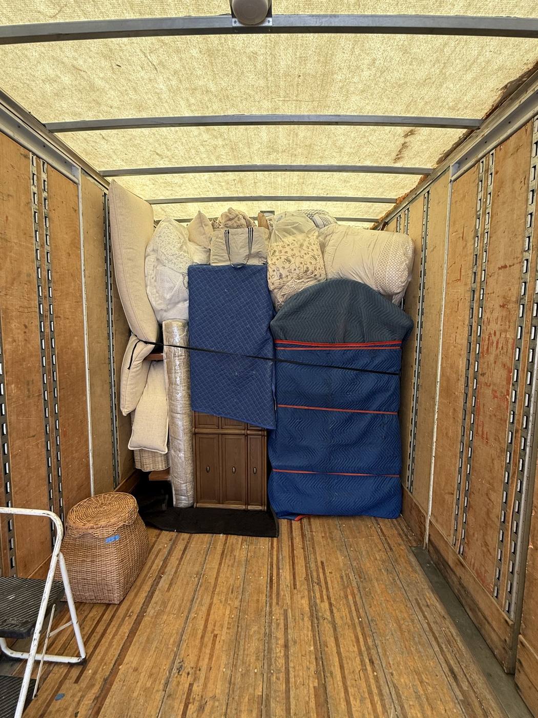 Furniture and mattresses stacked and secured inside a moving truck for a Northern Utah relocation